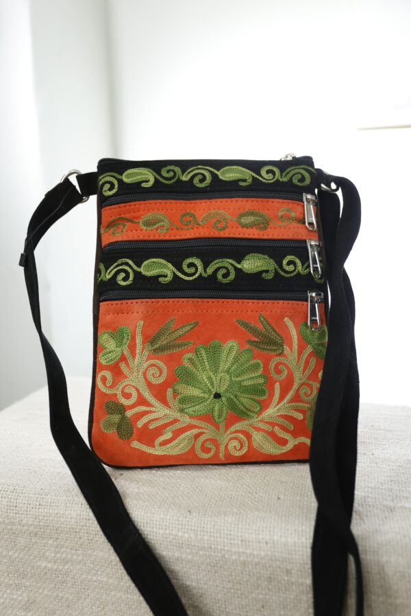 Oranje: Suede Fairtrade schoudertas oranje met groen borduur, drie ritsvakken – De Loohof